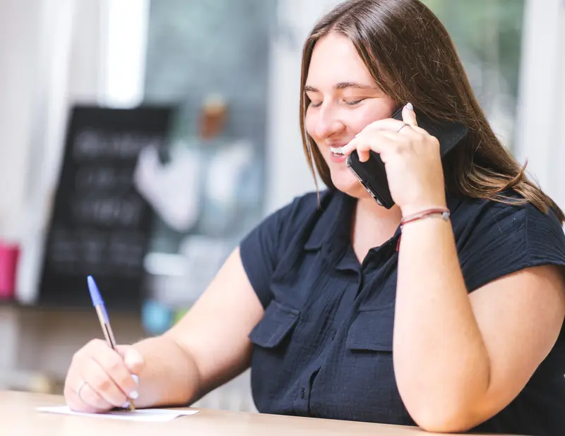 Une formatrice Nyki au téléphone, prenant des notes
